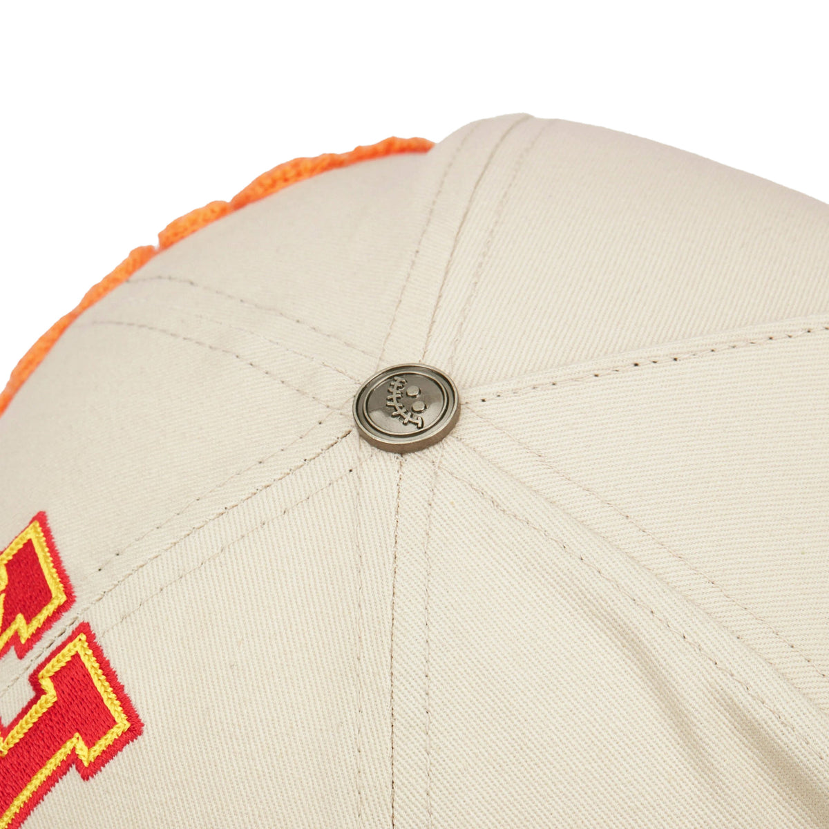 EBT trucker hat, Cream/Red, close-up of the metal smile button on the crown