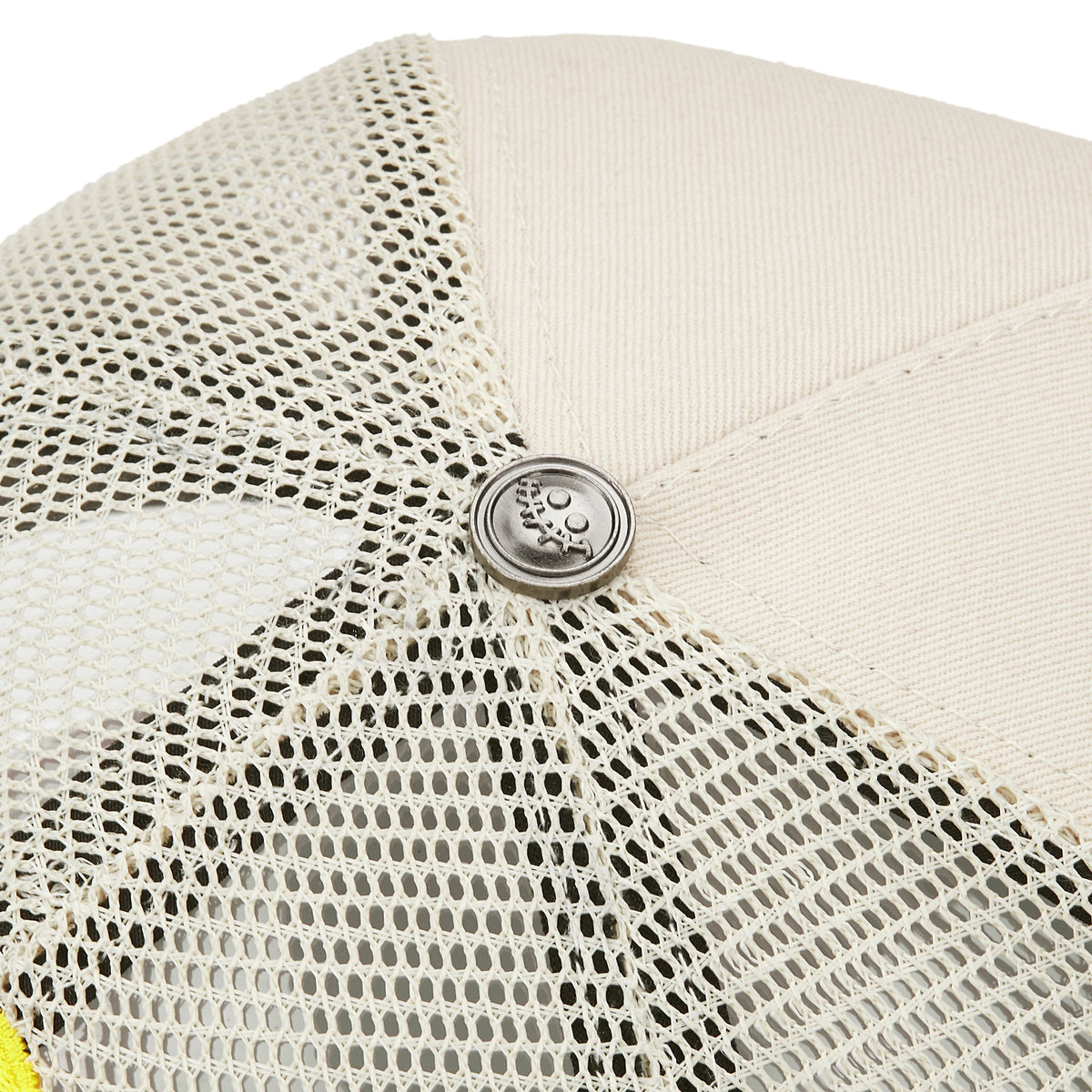 MANSON V2 trucker hat, Cream/Black, close-up of the silver metal smile button on the crown