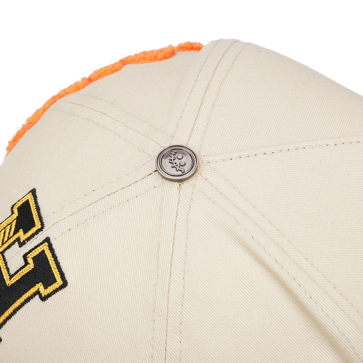 MYERS trucker hat, Cream/Black, close-up of the metal smile button on the crown